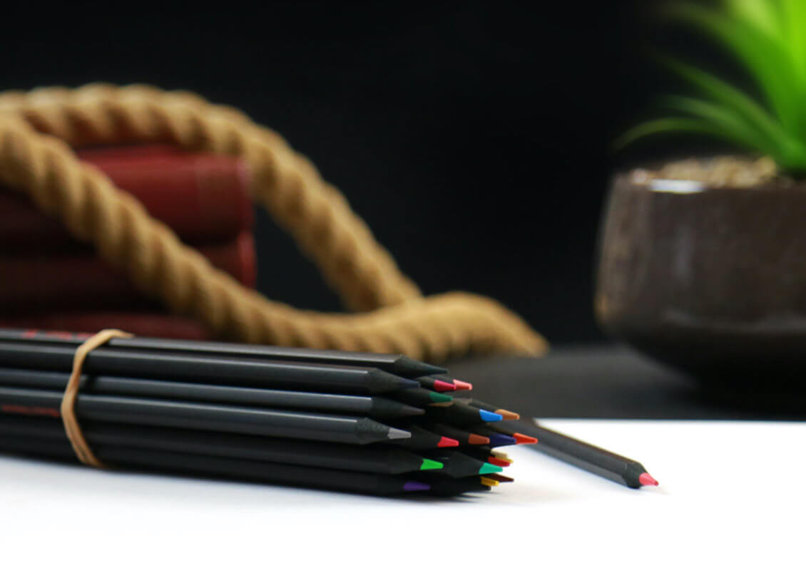 Black Widow pencils wrapped around a rubber band on a white pad
